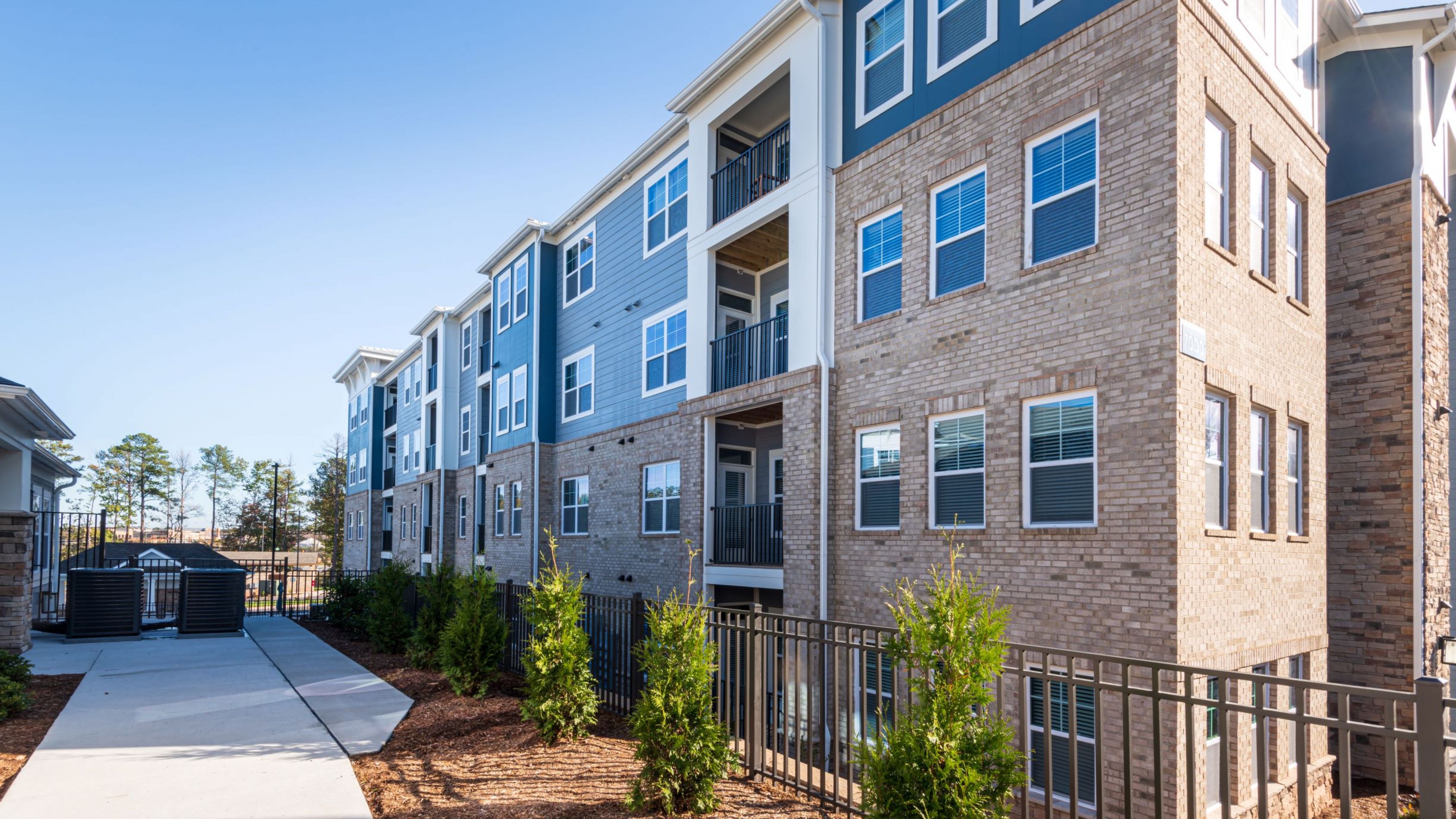 Hawthorne at Parkside apartments building exterior next to a sidewalk border by nice landscaping