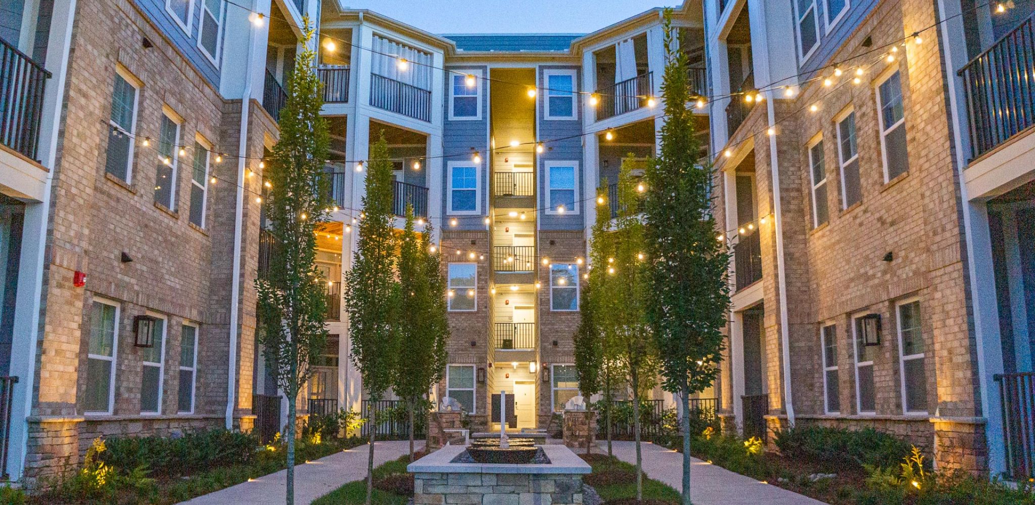 Hawthorne at Parkside pretty outdoor courtyard area with draping lights and a fire pit