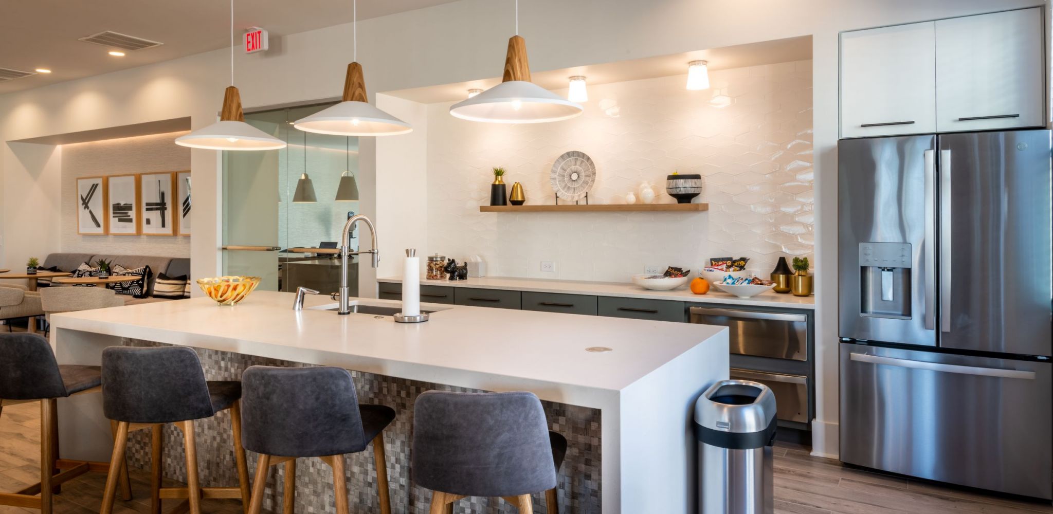 Hawthorne at Parkside resident clubhouse amenity area with entertainment space including a large island with chairs, stainless steel appliances, and a large sink