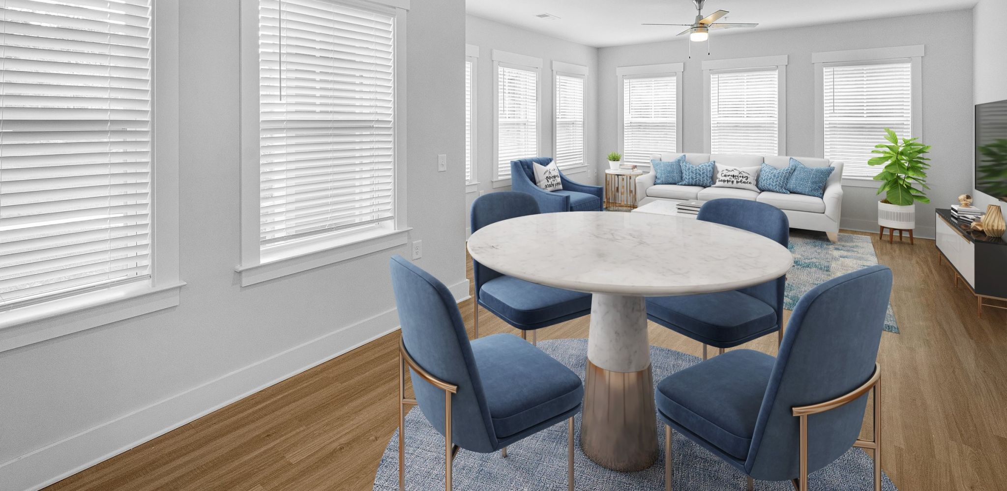 Hawthorne at Parkside apartment living space with dining area with small circle table and chairs and a spacious living room with a couch, chair, ceiling fan, and TV stand